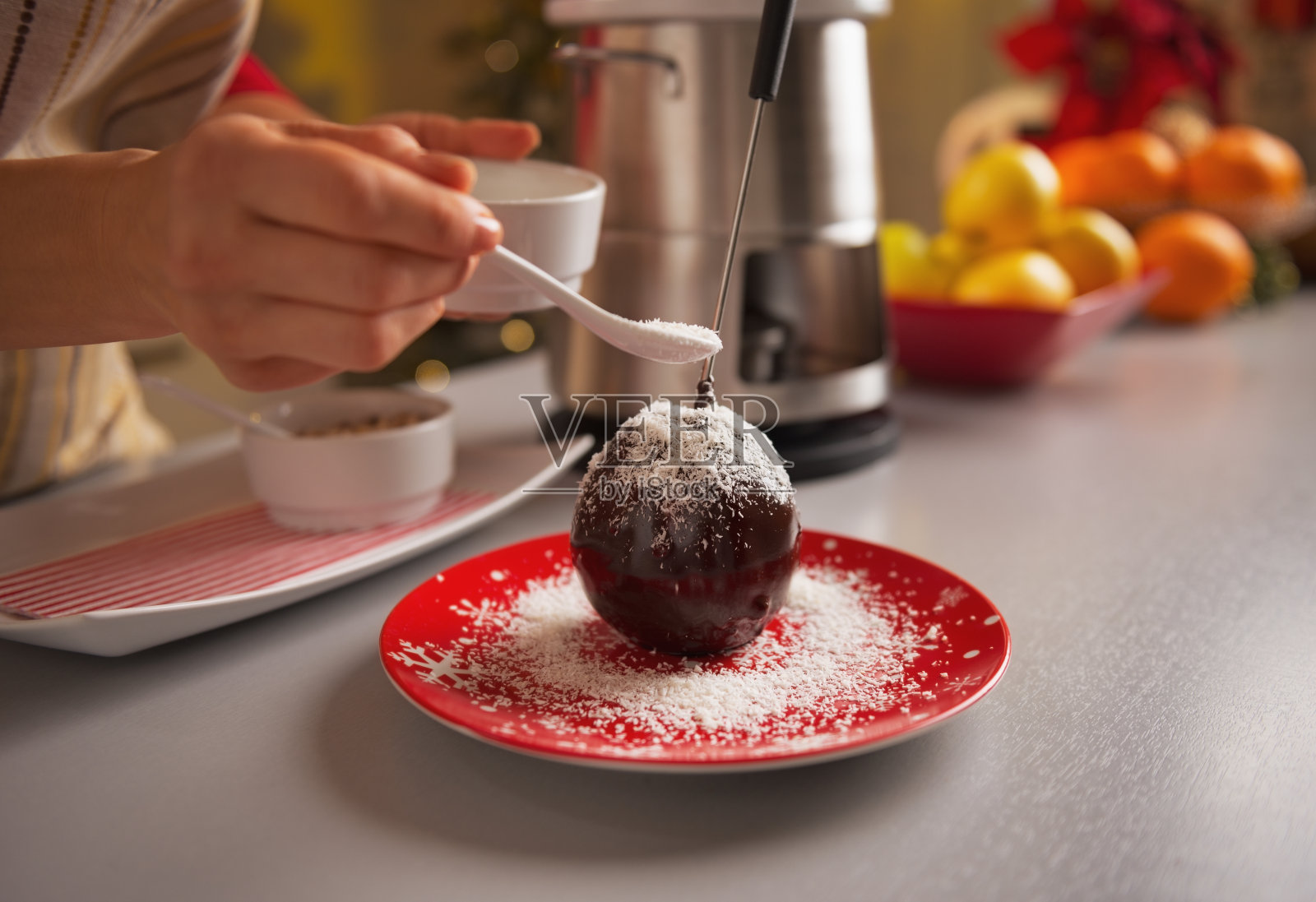 年轻的家庭主妇用巧克力釉装饰苹果的特写照片摄影图片