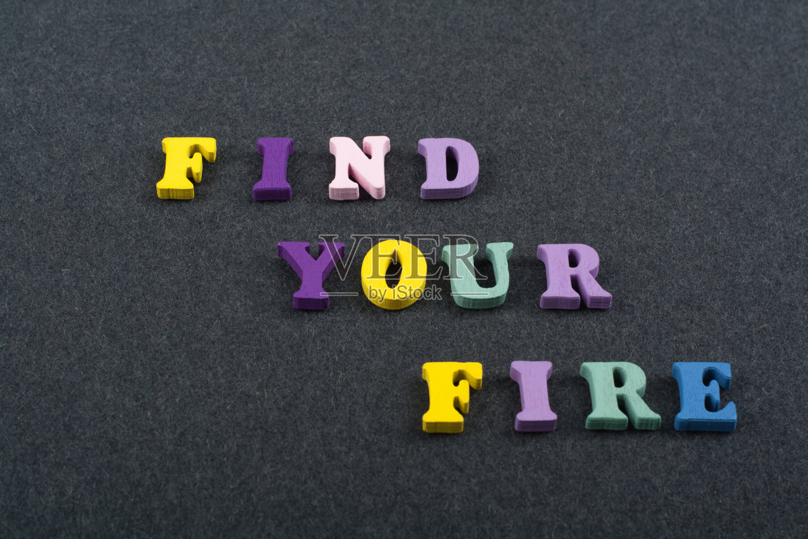 找到你的火词在黑板背景由彩色abc字母表块木制字母，复制空间的广告文本。学习英语的概念照片摄影图片