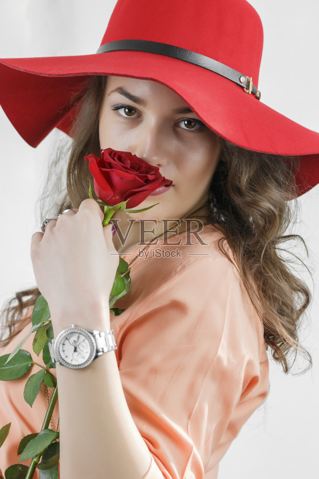 漂亮的年轻女孩拿着一朵玫瑰。照片摄影图片