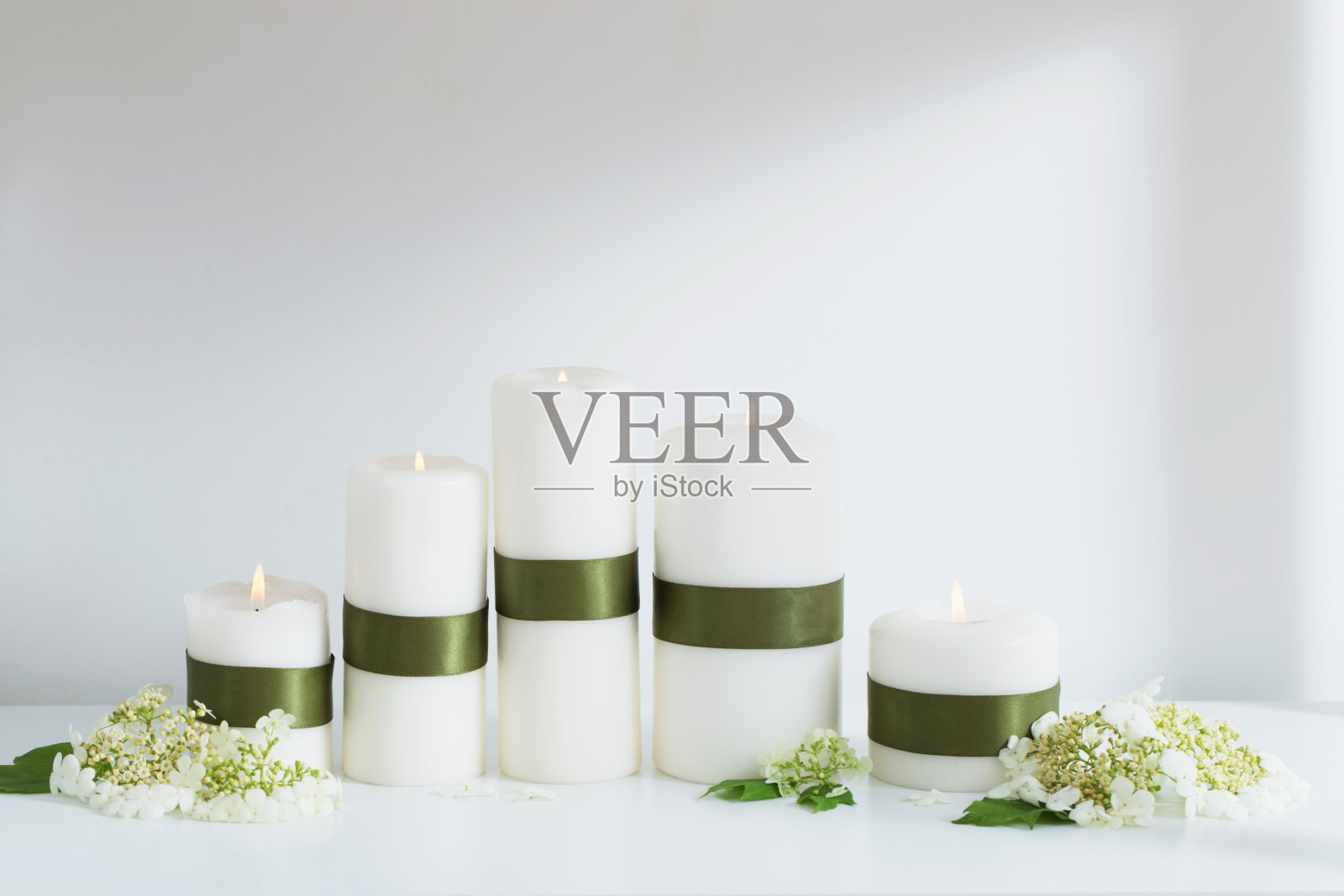 白色的蜡烛和花在白色的架子上照片摄影图片