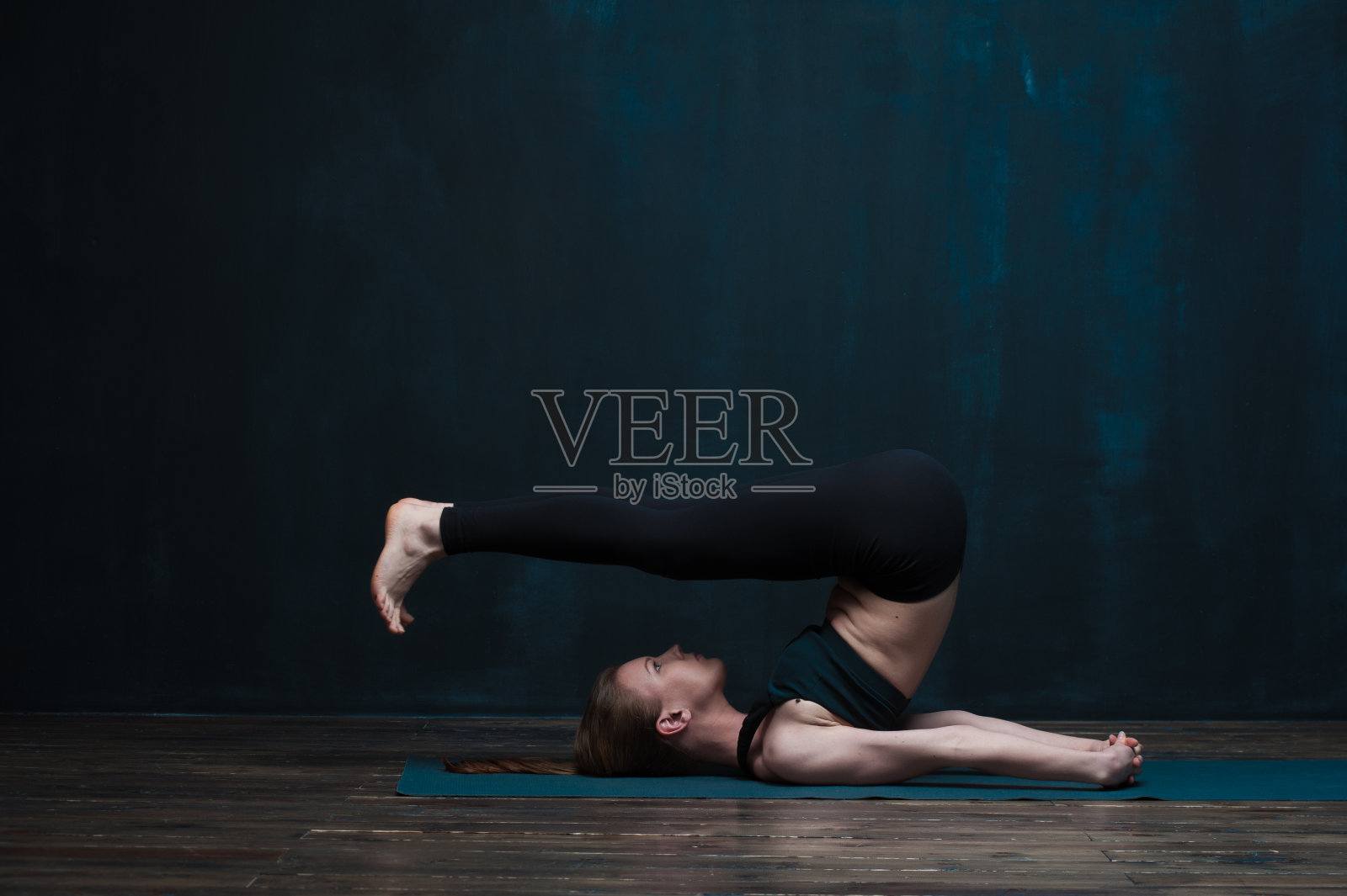 适合年轻女子在室内练习高级瑜伽照片摄影图片