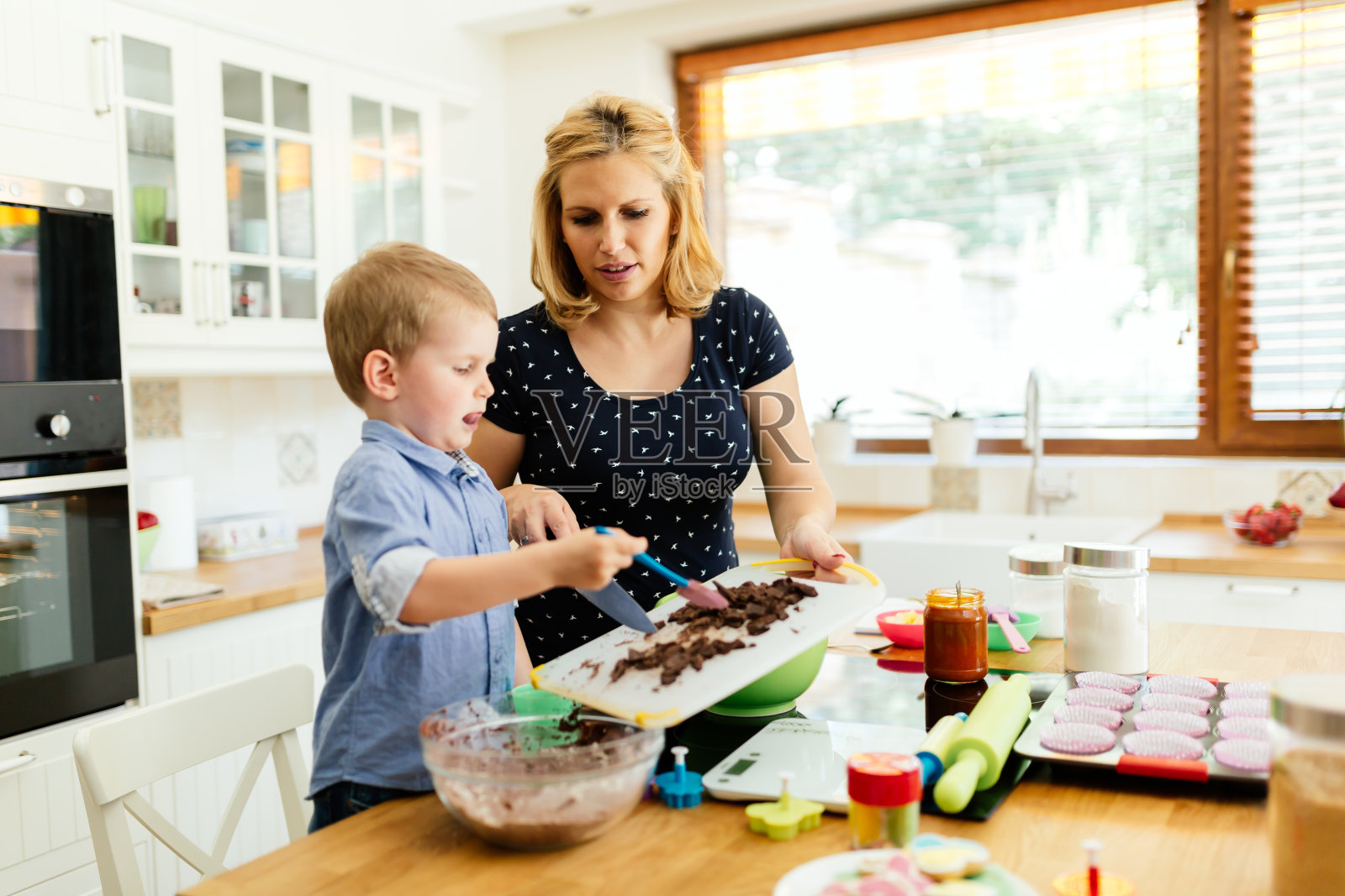 孩子在厨房帮妈妈做松饼照片摄影图片