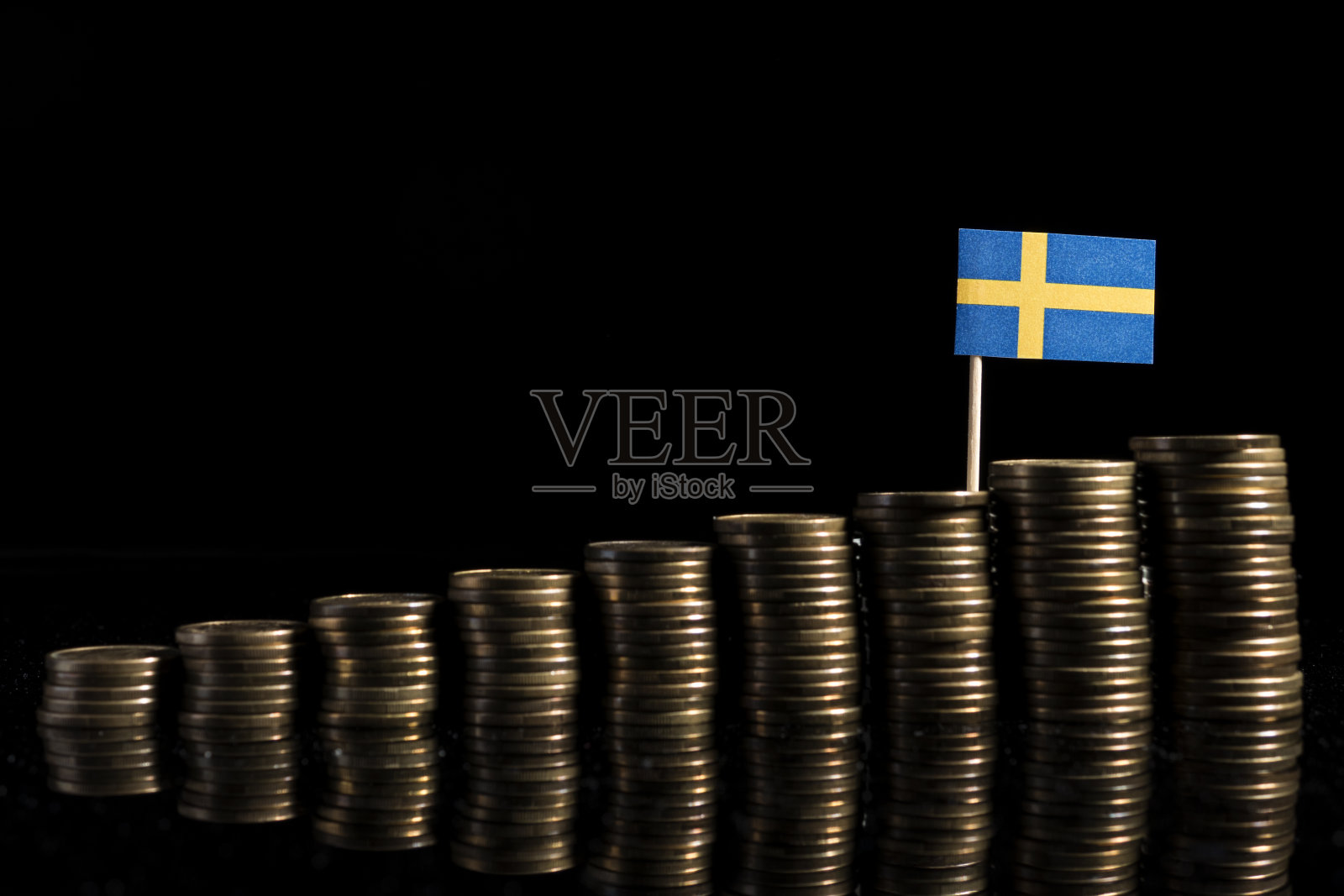 瑞典国旗与许多硬币孤立在黑色背景照片摄影图片