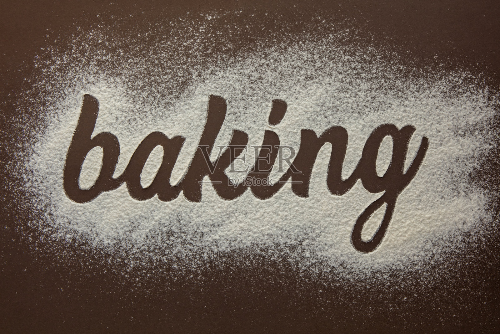 铭文烘焙，面粉书写。在棕色的背景上。照片摄影图片