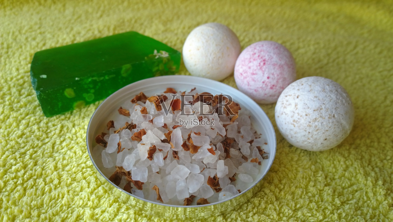 三个可爱的小浴盆炸弹，一个绿色的大肥皂和浴盐照片摄影图片