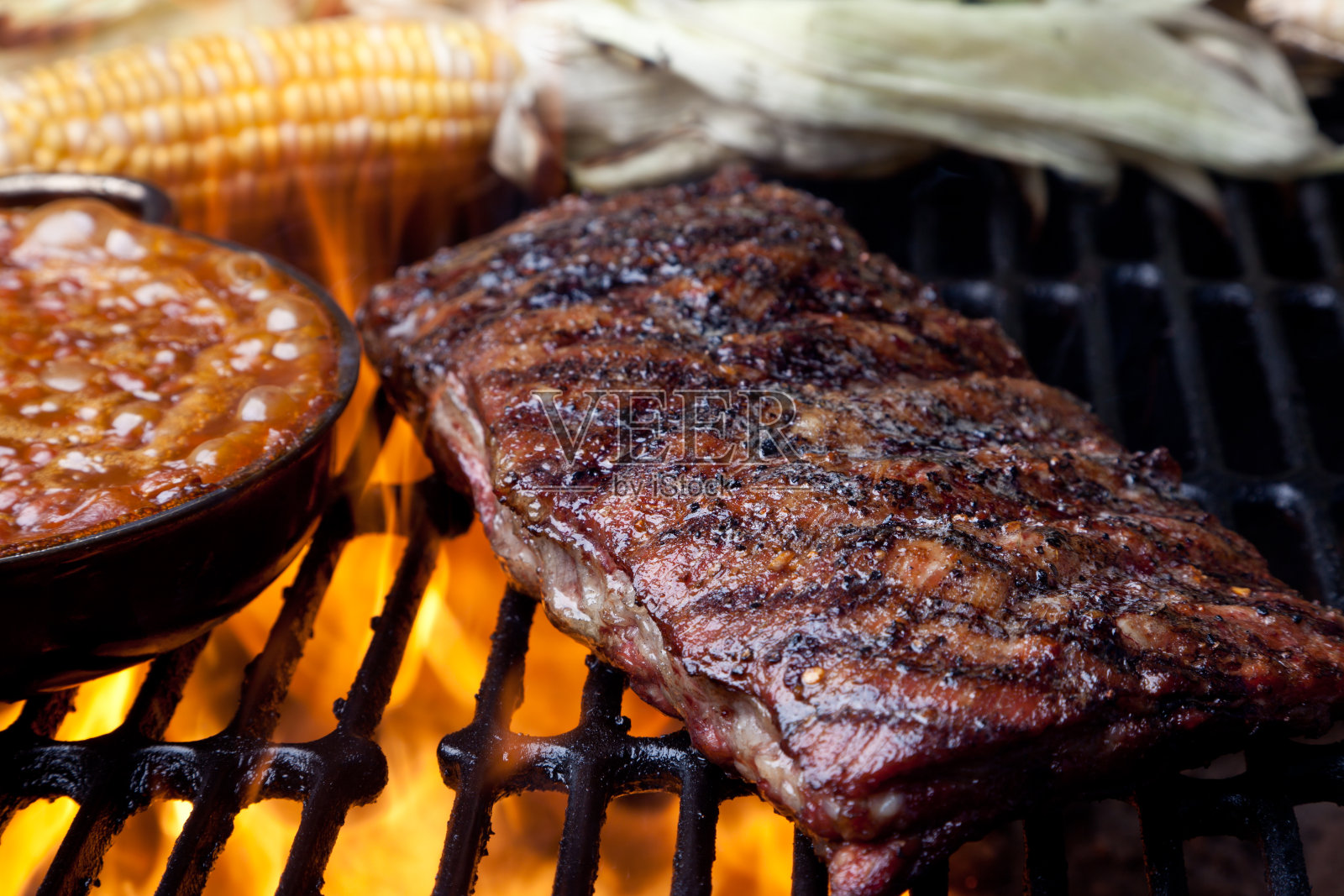 火焰烤架上的排骨和烘豆照片摄影图片