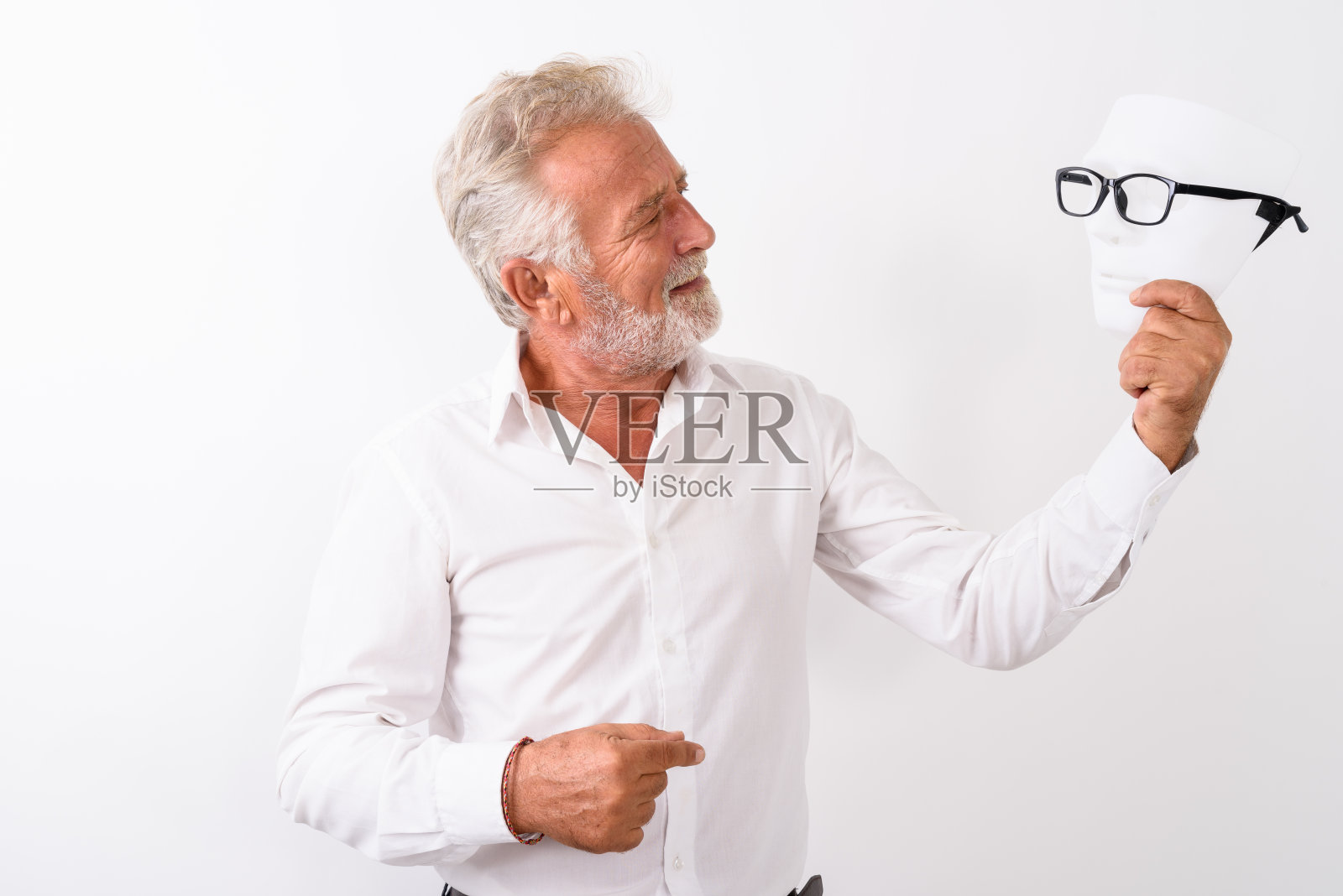 快乐的长胡子的老男人的侧面视图微笑着，看着白色的背景与眼镜的白色面具照片摄影图片