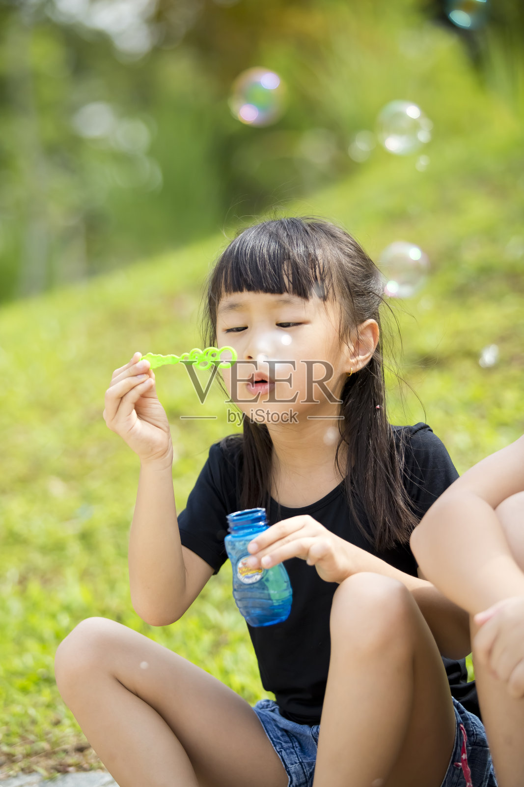 年轻的亚洲女孩在公园里玩沙子照片摄影图片