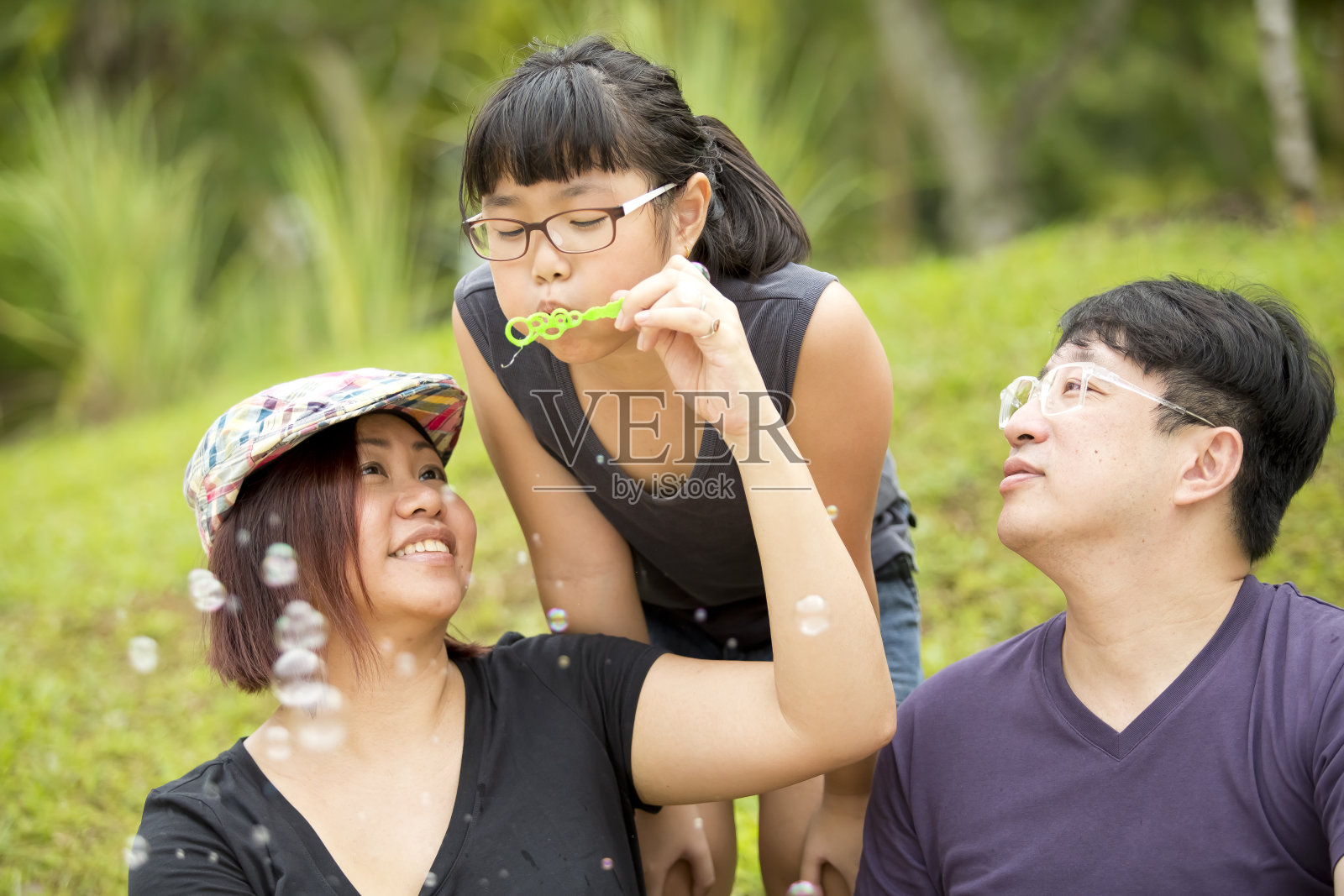 一个年轻的亚洲女孩在玩吹泡泡照片摄影图片