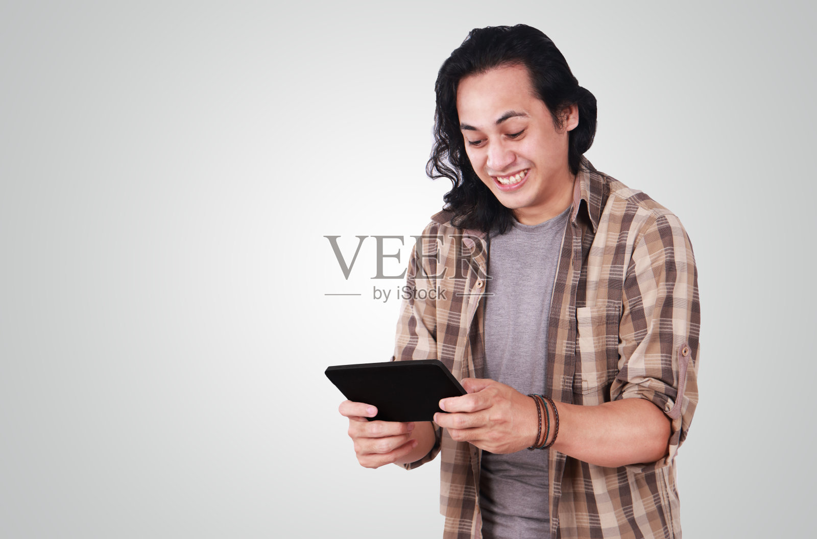 有趣的年轻亚洲人在平板电脑上玩游戏照片摄影图片