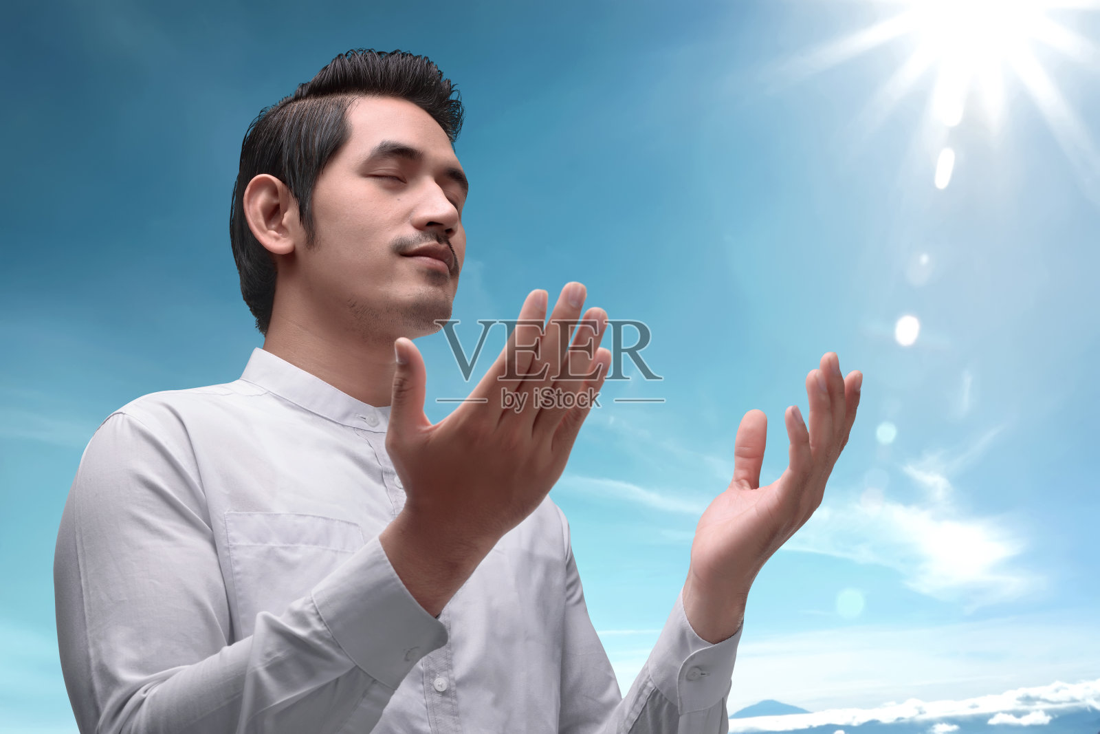 英俊的亚洲穆斯林男子举起手祈祷照片摄影图片