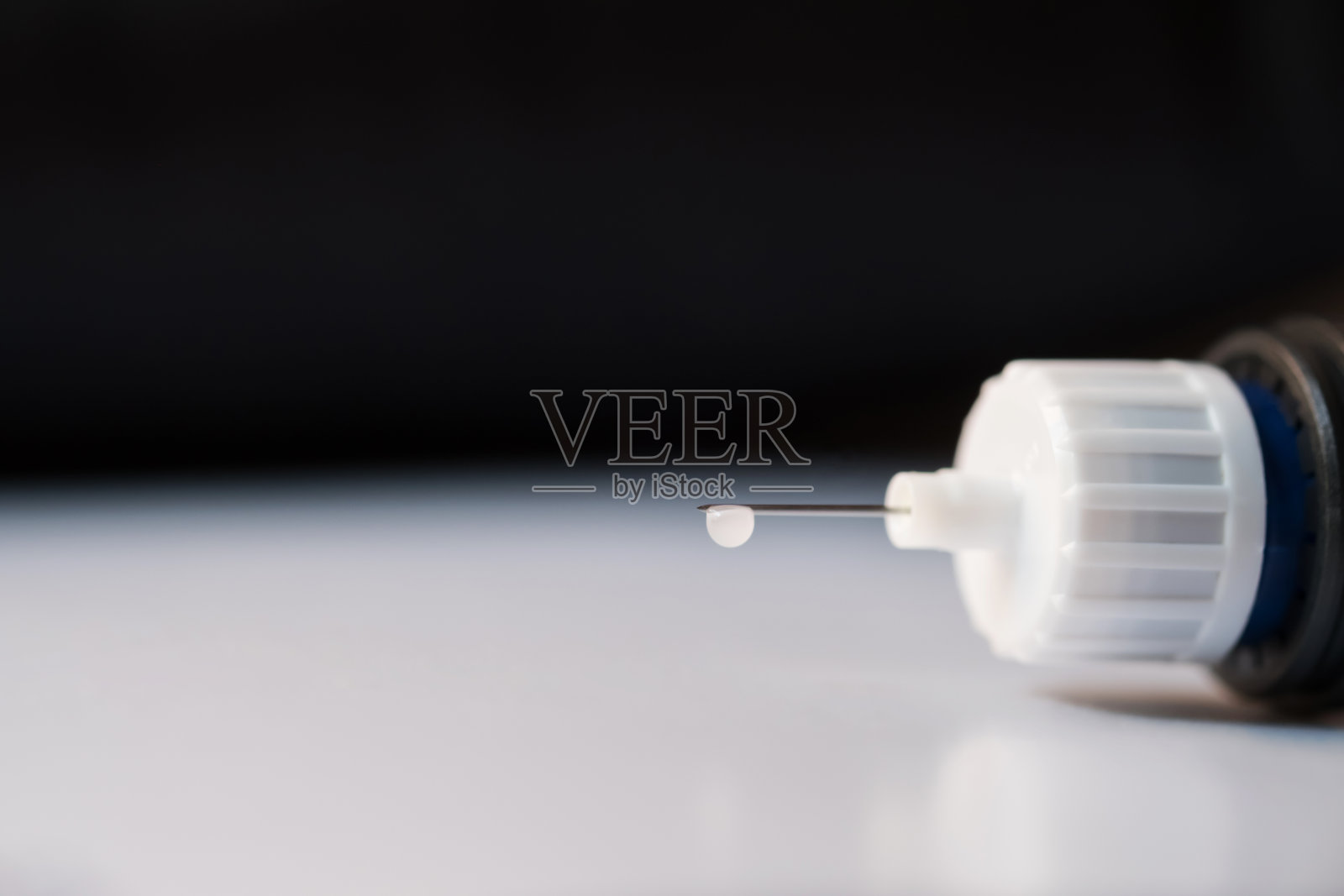 合糖尿病笔注射针和糖尿病药。挂着一滴胰岛素。照片摄影图片