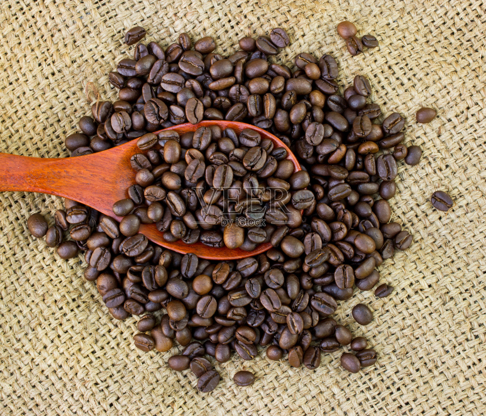 木勺和粗麻袋上的咖啡豆。照片摄影图片