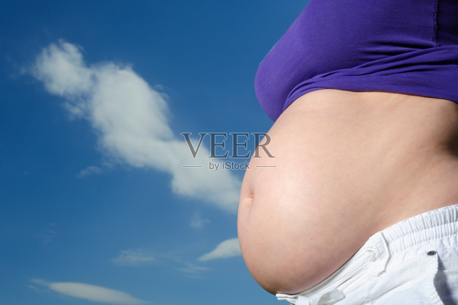 赤裸的孕妇肚子对着蓝天照片摄影图片