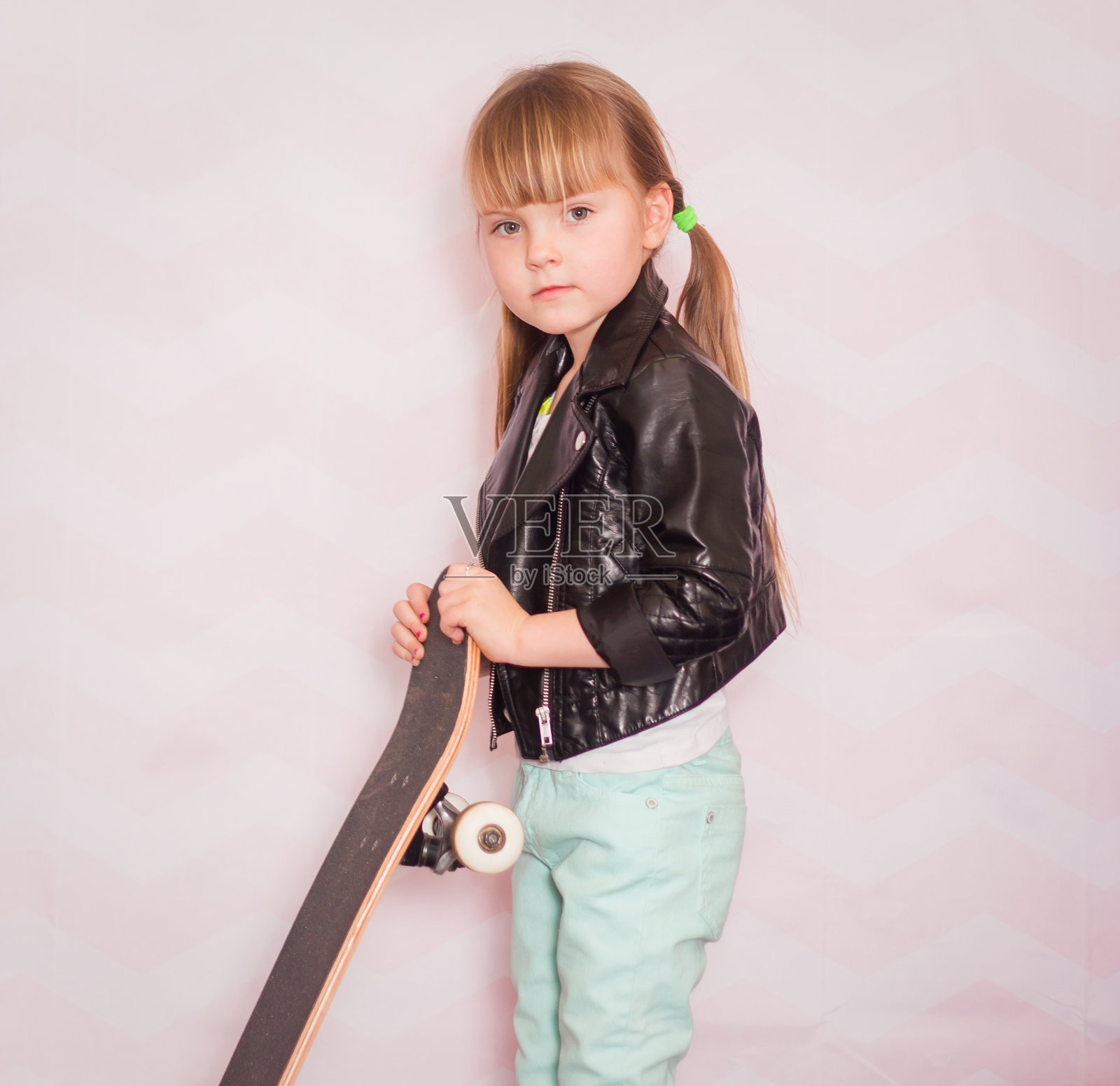 穿着皮夹克玩滑板的小女孩照片摄影图片