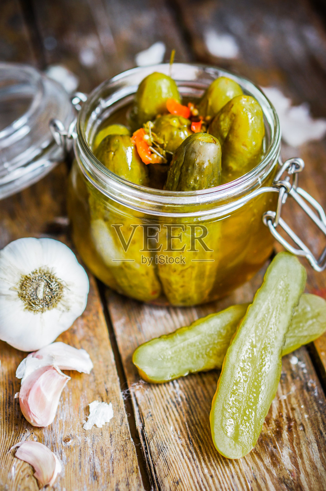 腌菜和大蒜在玻璃罐在乡村木制背景照片摄影图片