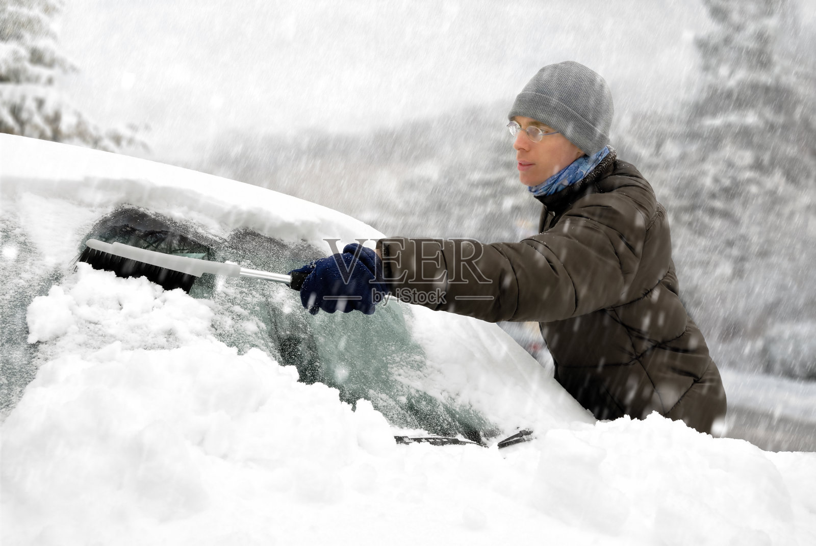 一个男人从他的车里清除雪照片摄影图片