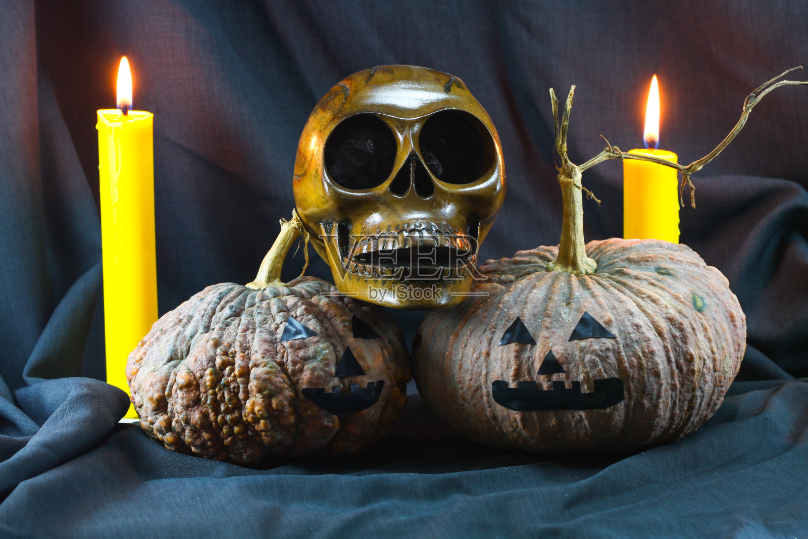 人类头骨和南瓜在黑色的背景，万圣节的背景。照片摄影图片