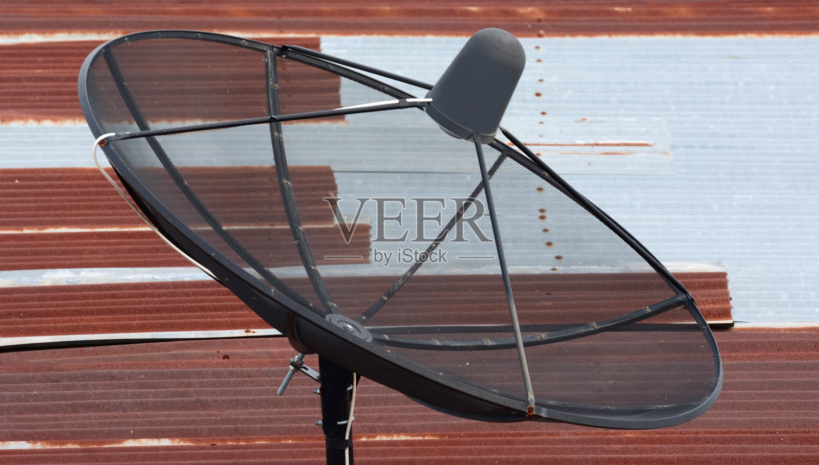 旧锌屋顶上的卫星电视接收器照片摄影图片