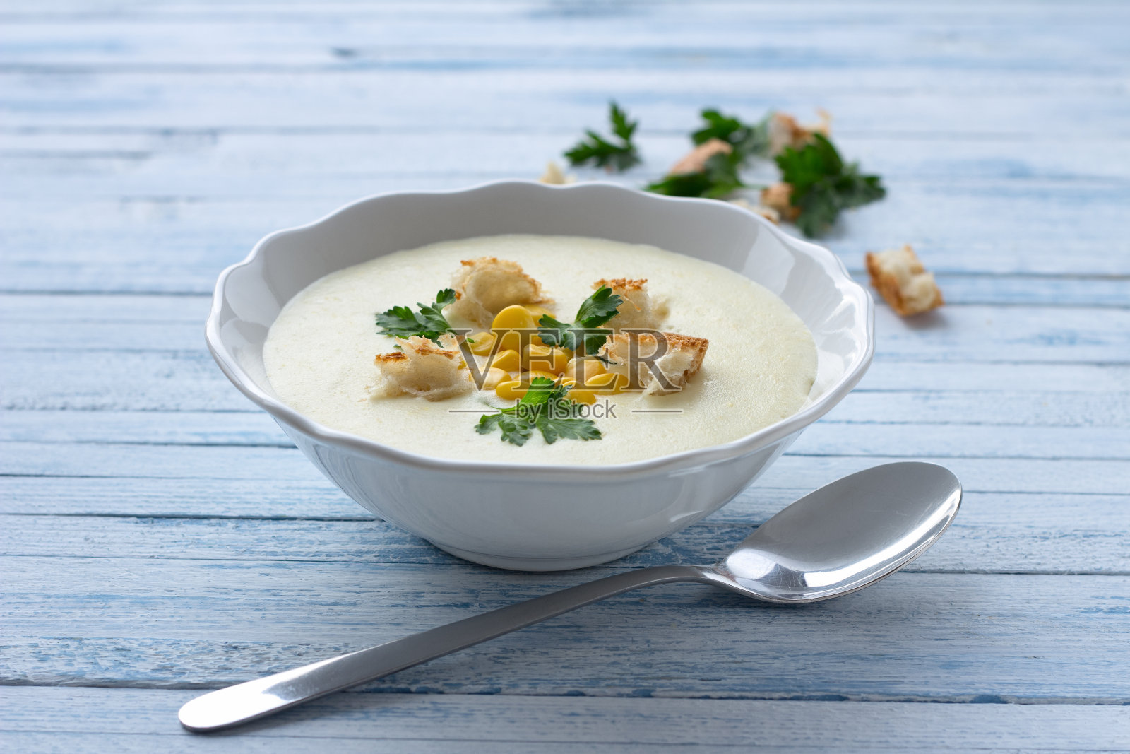 蔬菜奶油汤，配玉米，面包丁和欧芹照片摄影图片