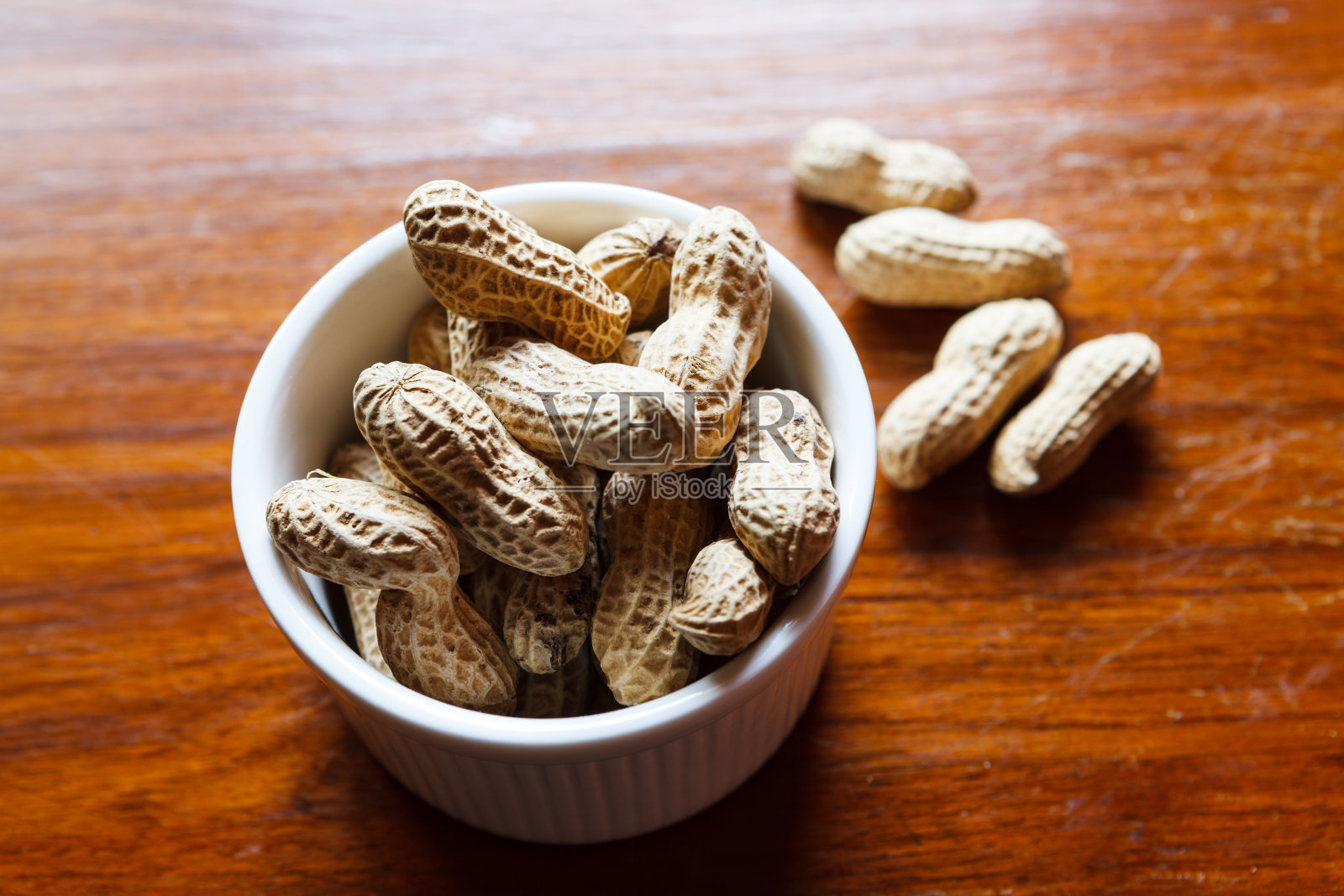 木桌上放着一碗花生照片摄影图片