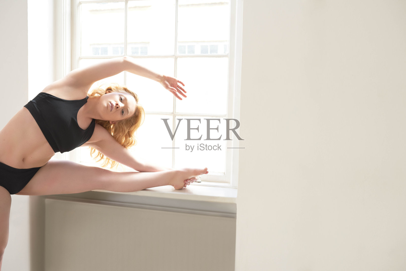 女人伸展她的手臂和腿在健身服装照片摄影图片