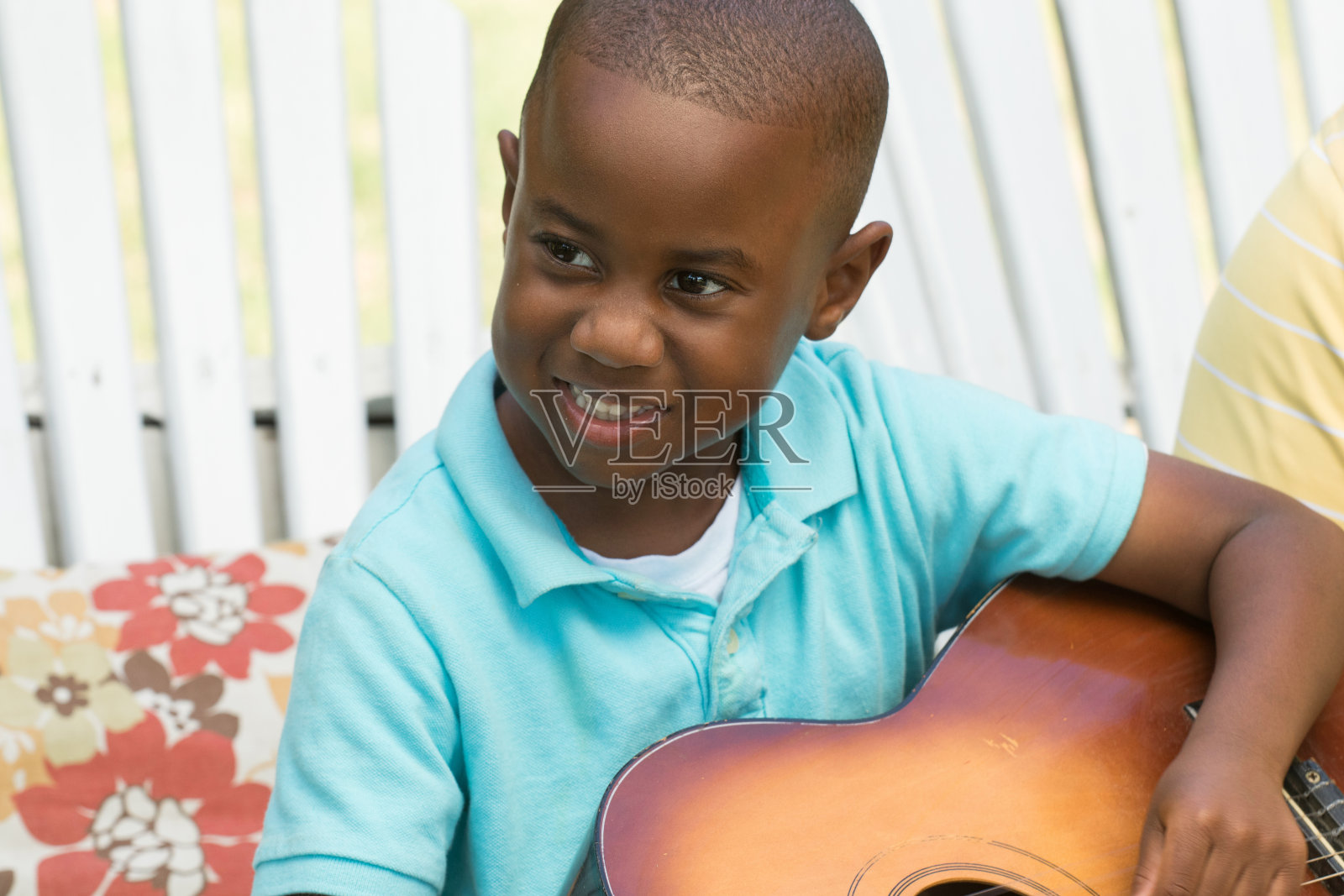 非裔美国小男孩弹吉他。照片摄影图片