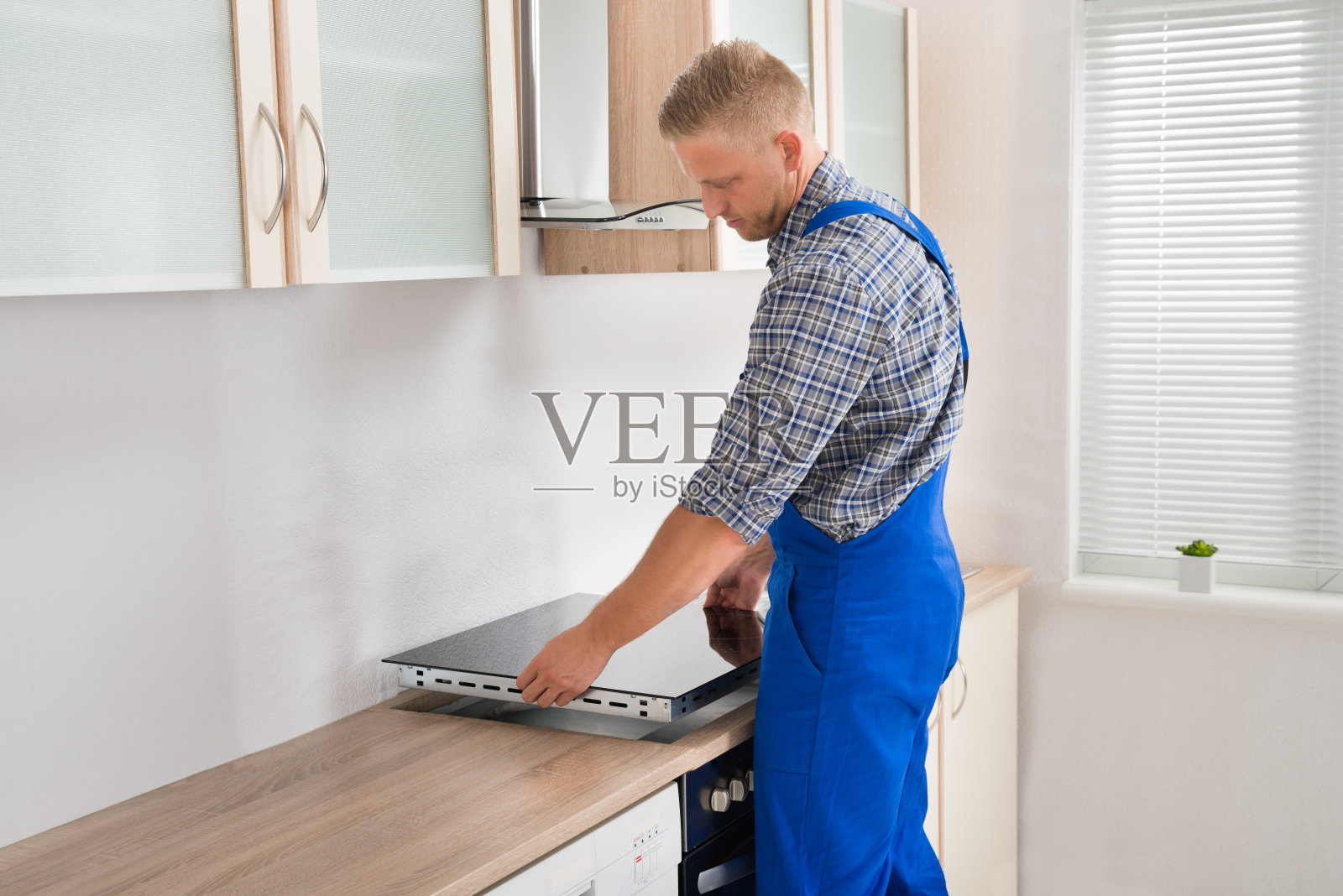 修理工正在安装电磁炉照片摄影图片