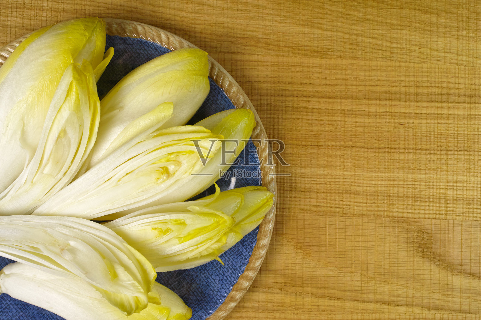 放在蓝色盘子里的新鲜菊苣沙拉叶照片摄影图片