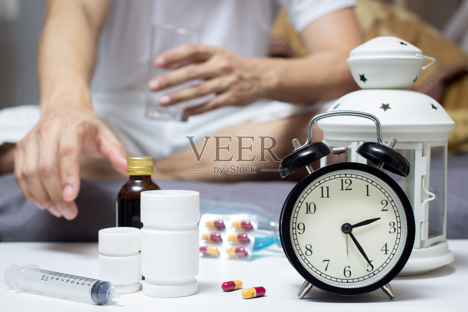 在床上服用平板电脑和水的亚洲男人照片摄影图片