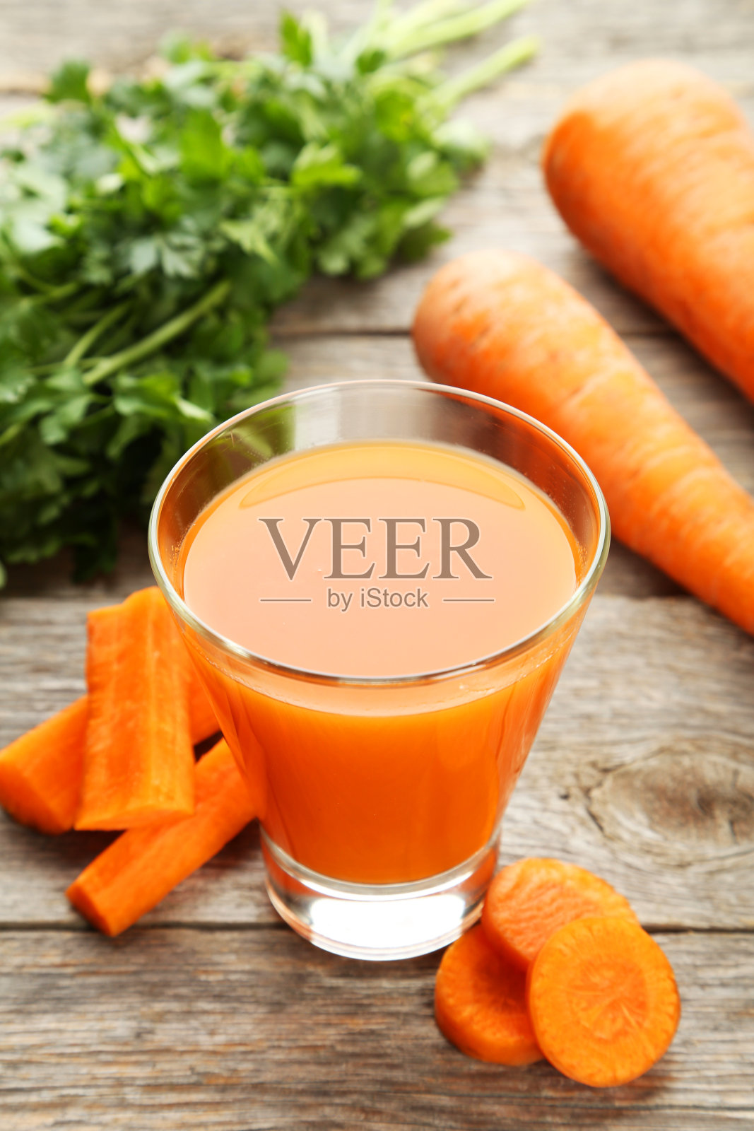 灰色木质背景上的胡萝卜汁照片摄影图片
