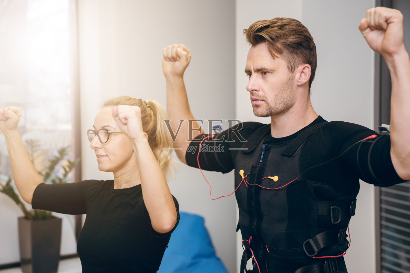 认真的运动员在健身房和私人教练一起锻炼照片摄影图片