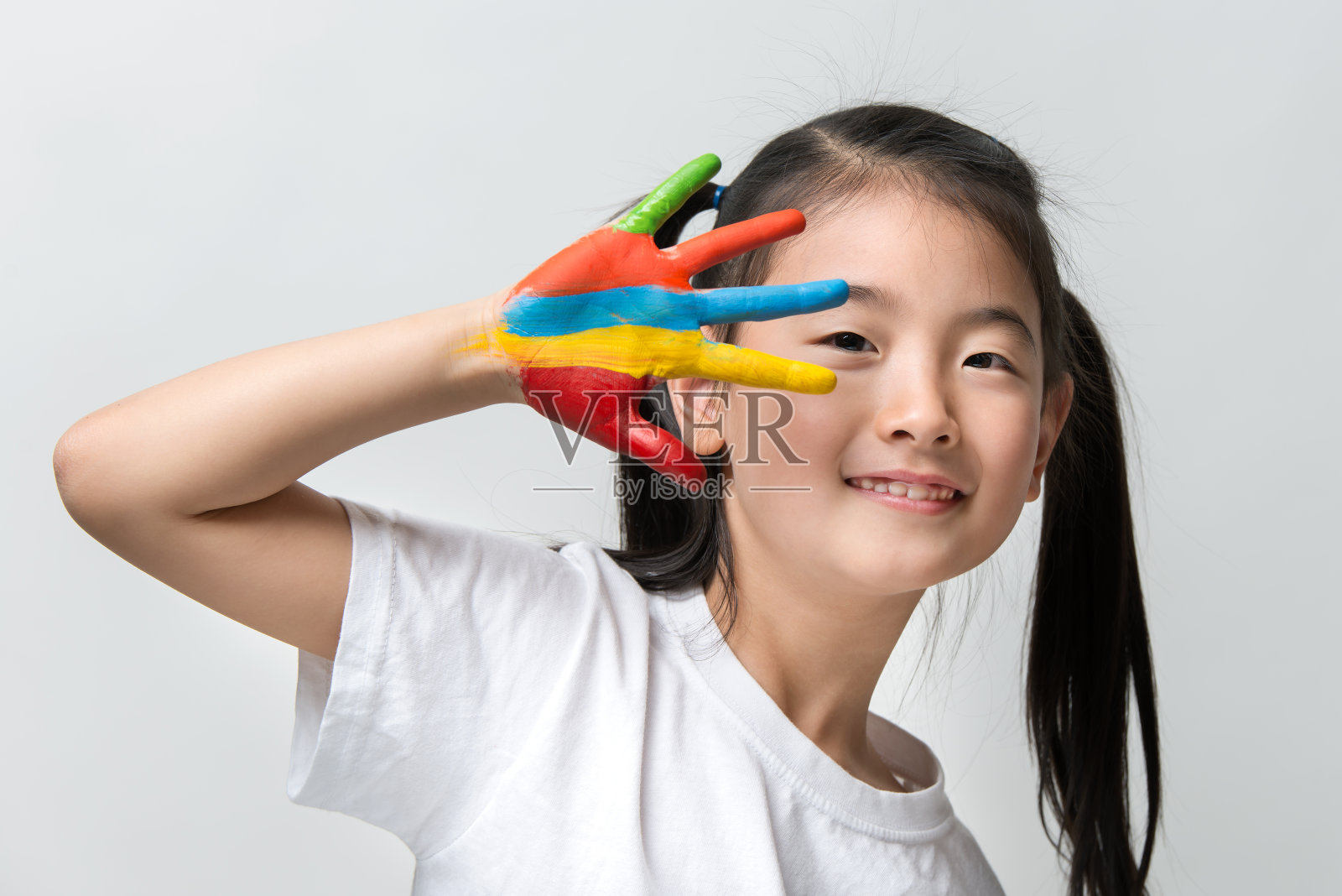 一个亚洲小女孩，手上涂着彩色颜料照片摄影图片