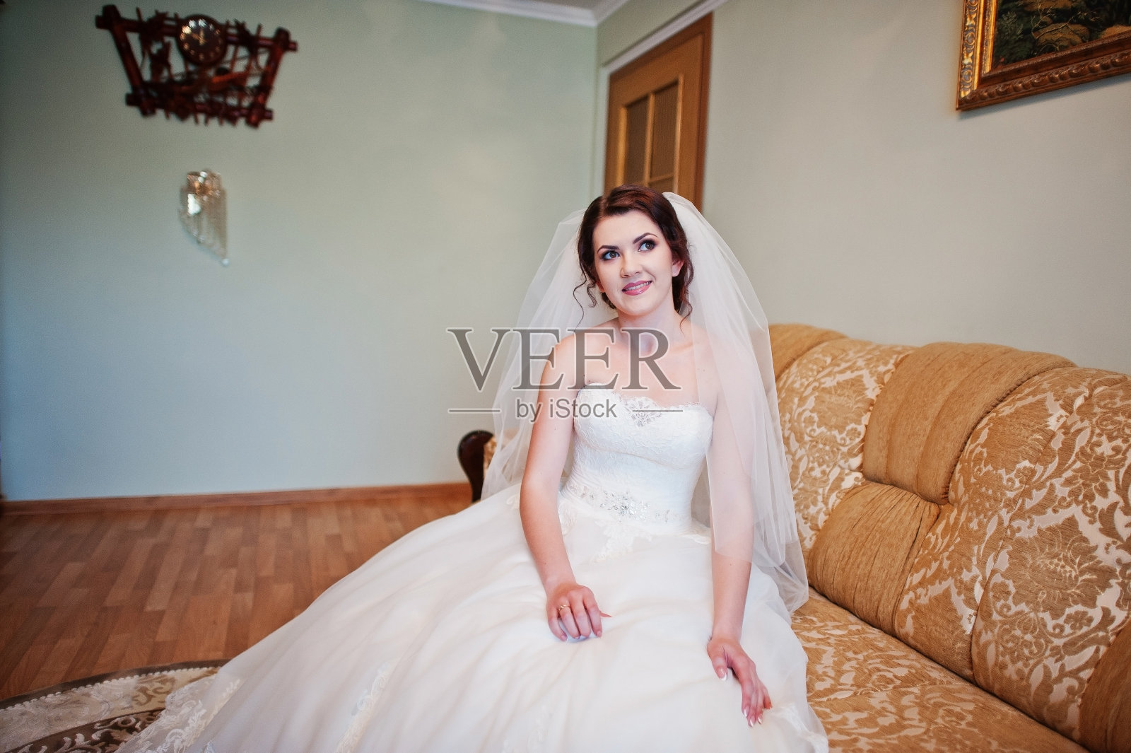 温柔的黑发新娘坐在床上在她的房间在早上结婚的日子。照片摄影图片