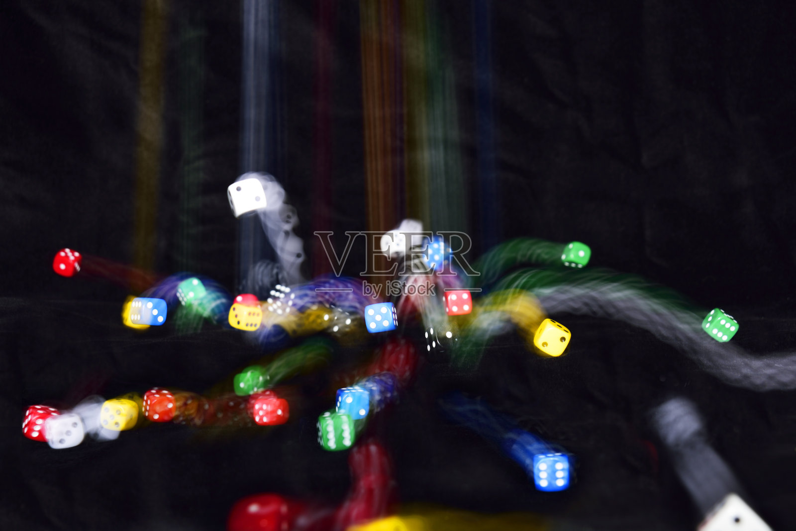 骰子;不同的颜色;在运动;在黑色背景下。照片摄影图片