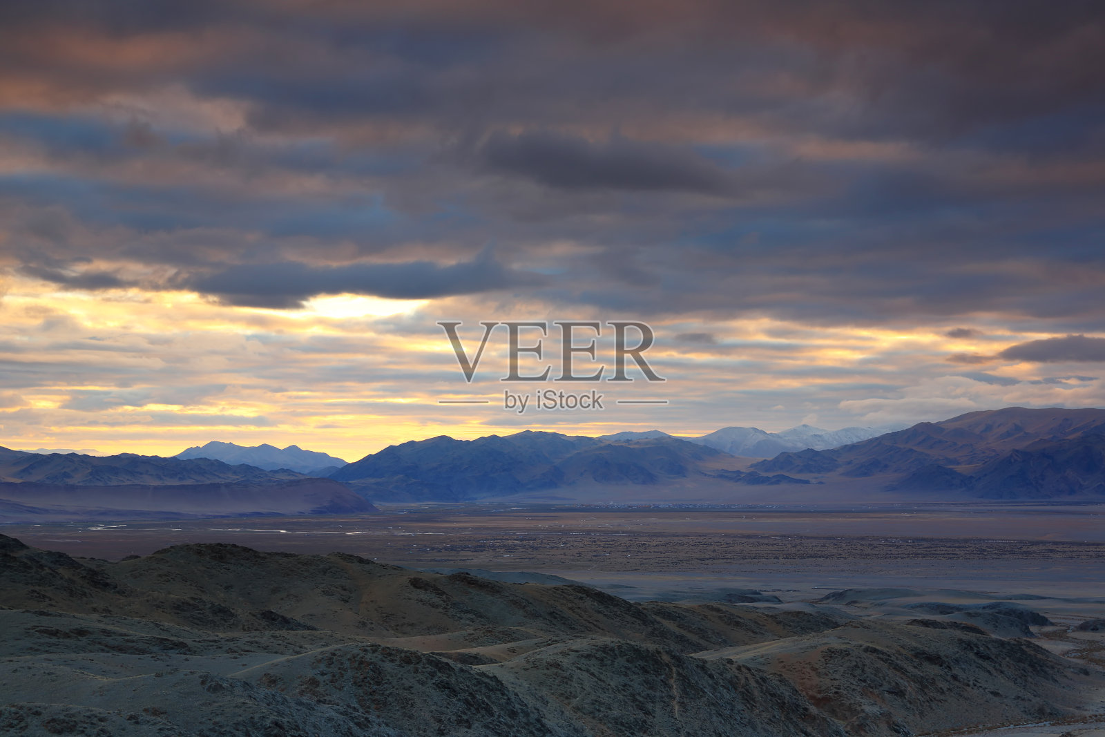 高原草原与山脉多云戏剧性的蓝天在美丽的日出照片摄影图片