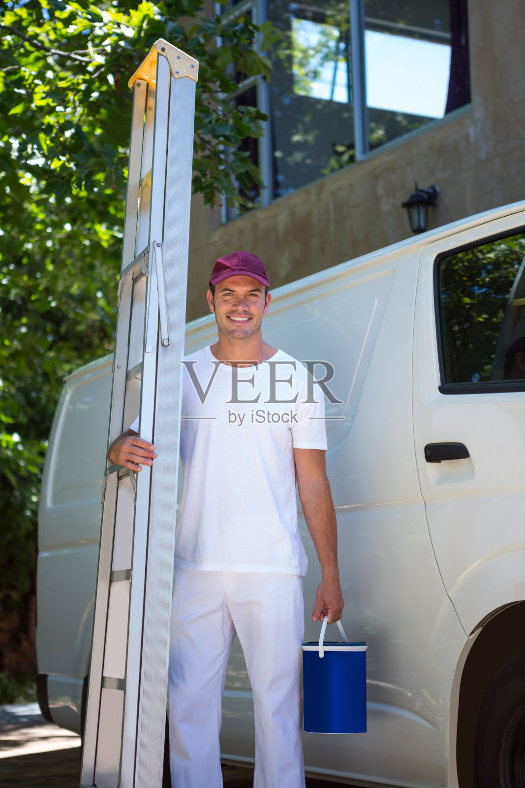 拿着活梯和水桶的油漆工照片摄影图片