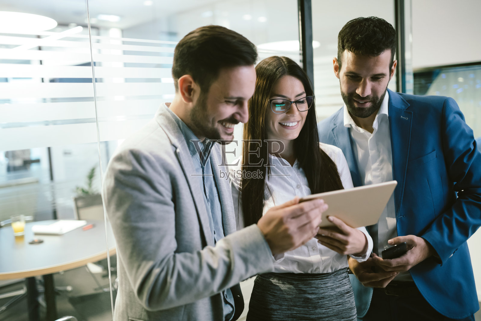 快乐的商务人士在办公室看平板电脑照片摄影图片