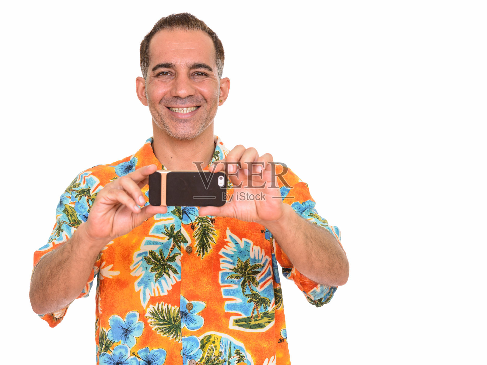 波斯裔中年游客面带微笑，准备度假，用手机拍照并看向镜头照片摄影图片