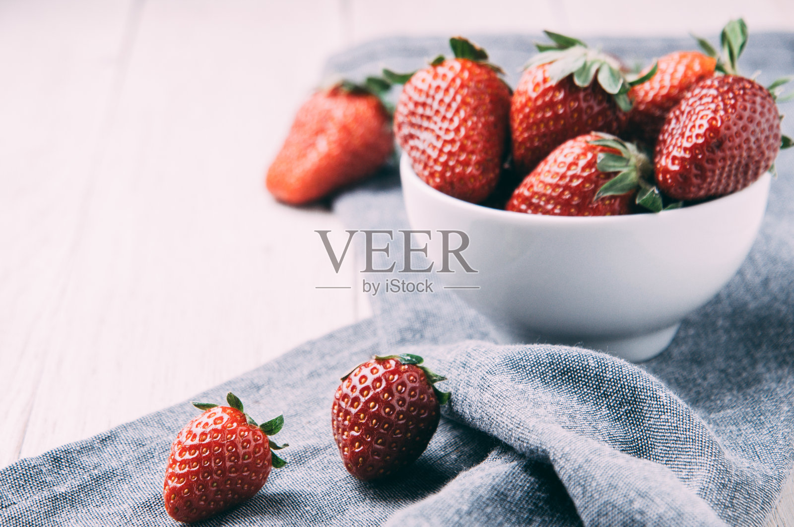 成熟的草莓在白色的木质背景上照片摄影图片