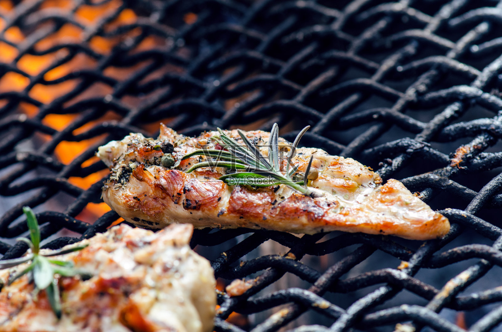 用香料和迷迭香将烤架上的烤鸡片。卤汁鸡胸肉在火烤蔬菜。健康食品。烧烤酱。照片摄影图片