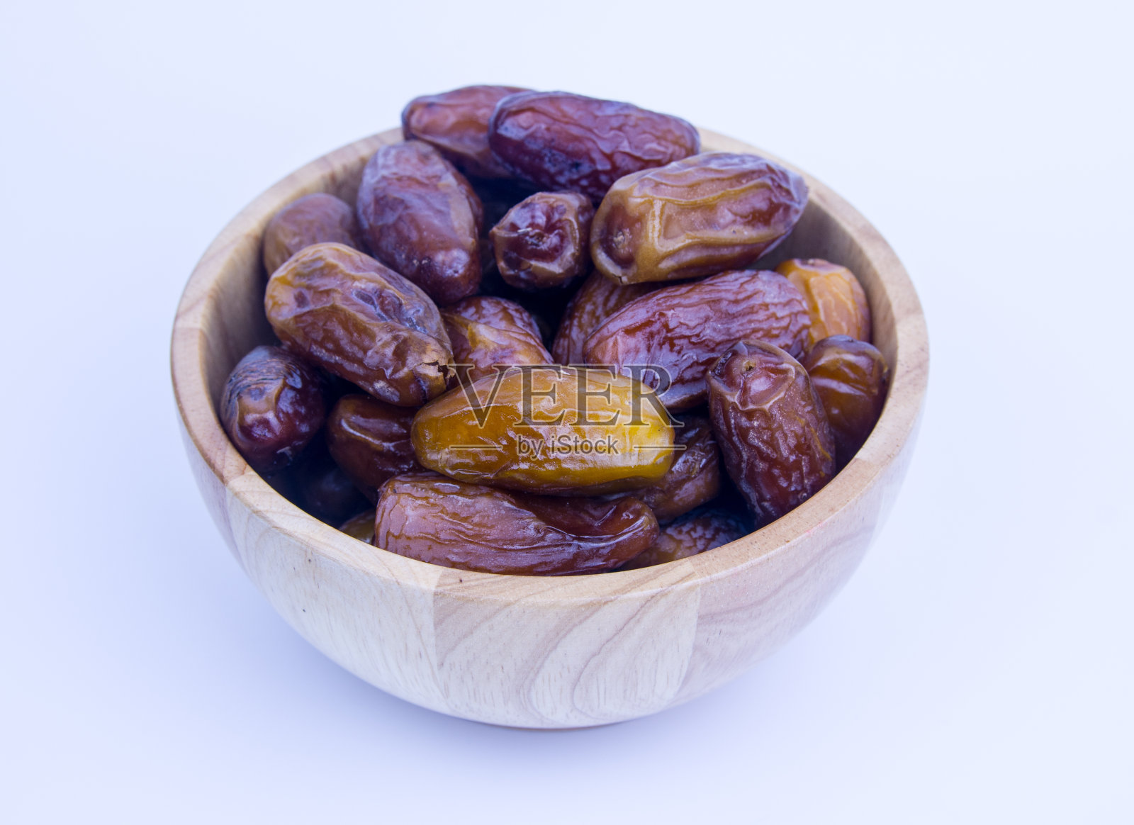 在木背景上的一盘干枣的特写。照片摄影图片