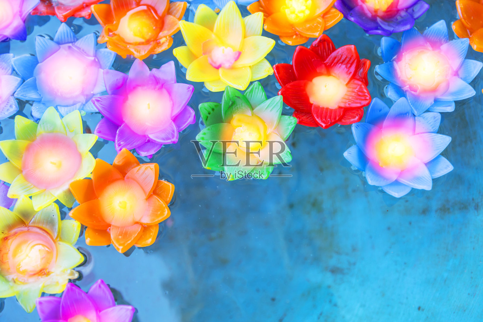 五彩缤纷的花灯烛光漂浮在池塘的水里。照片摄影图片