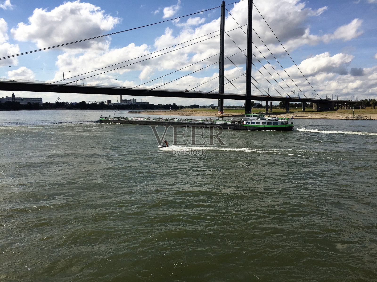 水上摩托艇和货轮驶过莱茵河，德国杜塞尔多夫。莱茵尼布鲁克在后面。照片摄影图片