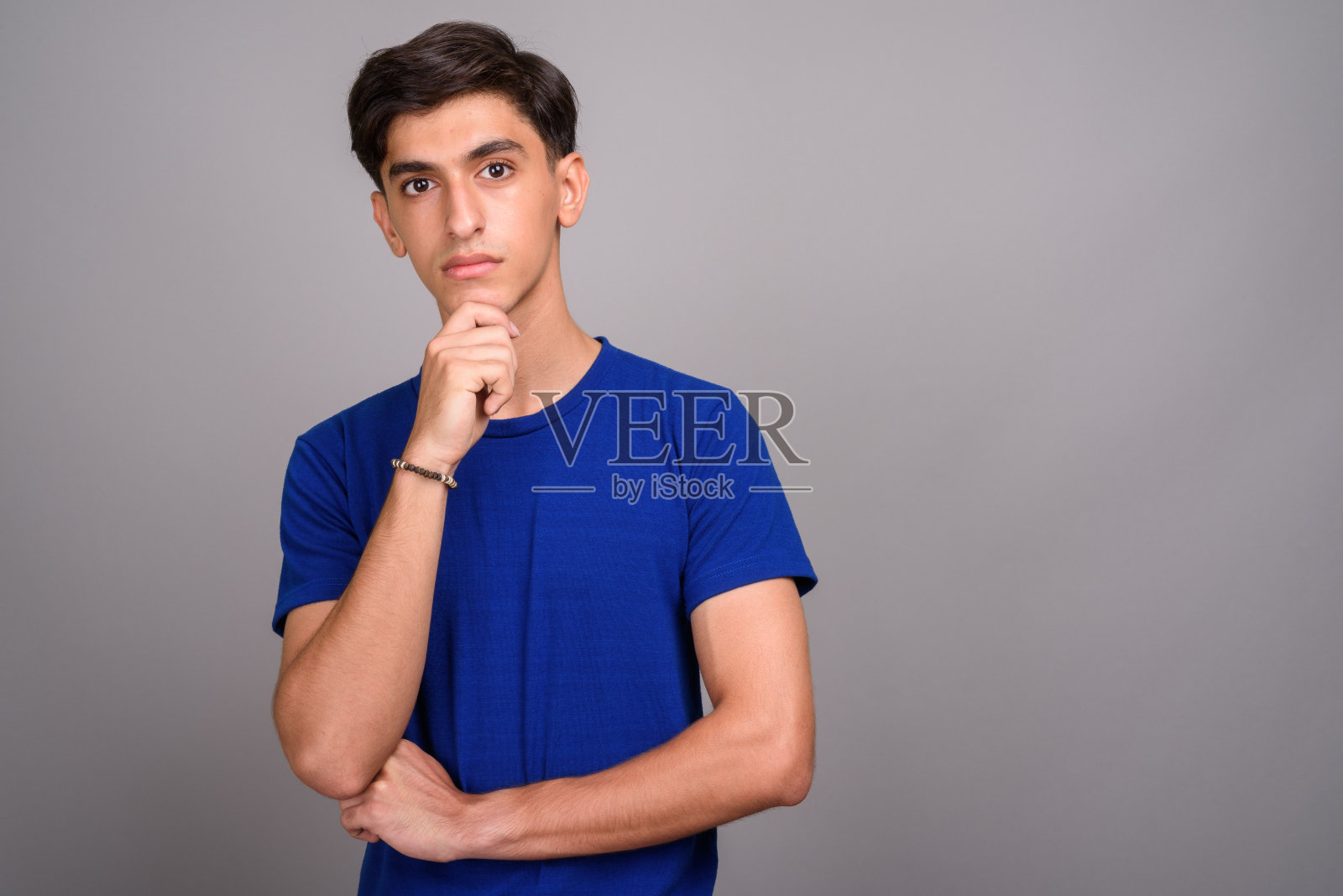 灰色背景前的年轻波斯少年（影棚拍摄）照片摄影图片