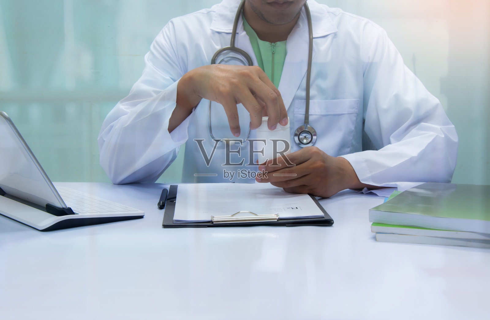 医生在医院前台检查药品。照片摄影图片