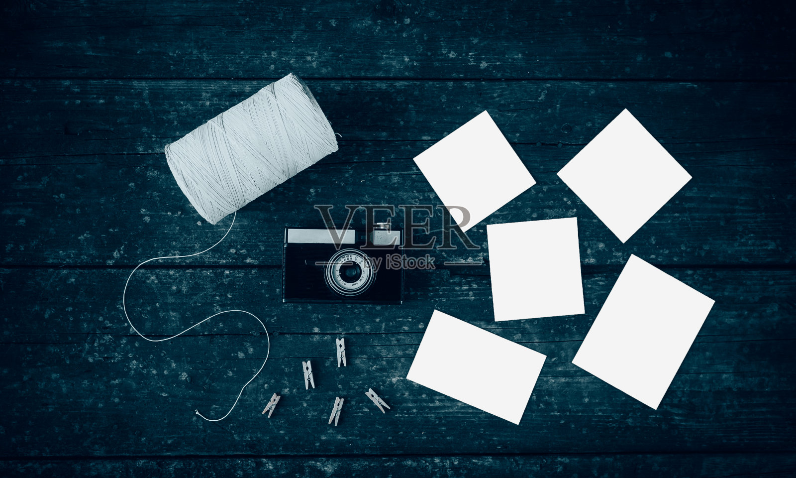 木桌上放着复古相机、空照片、晒衣夹和线轮。照片摄影图片