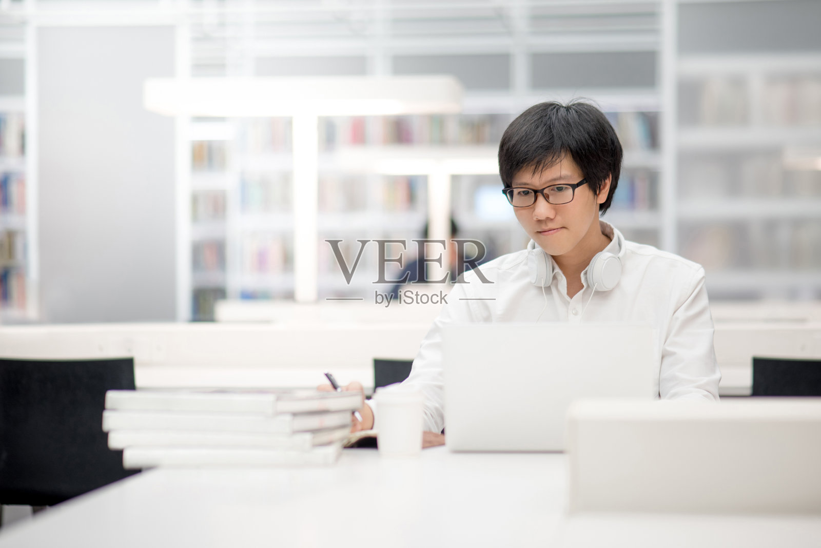年轻的亚洲大学生在图书馆使用笔记本电脑和笔记本照片摄影图片