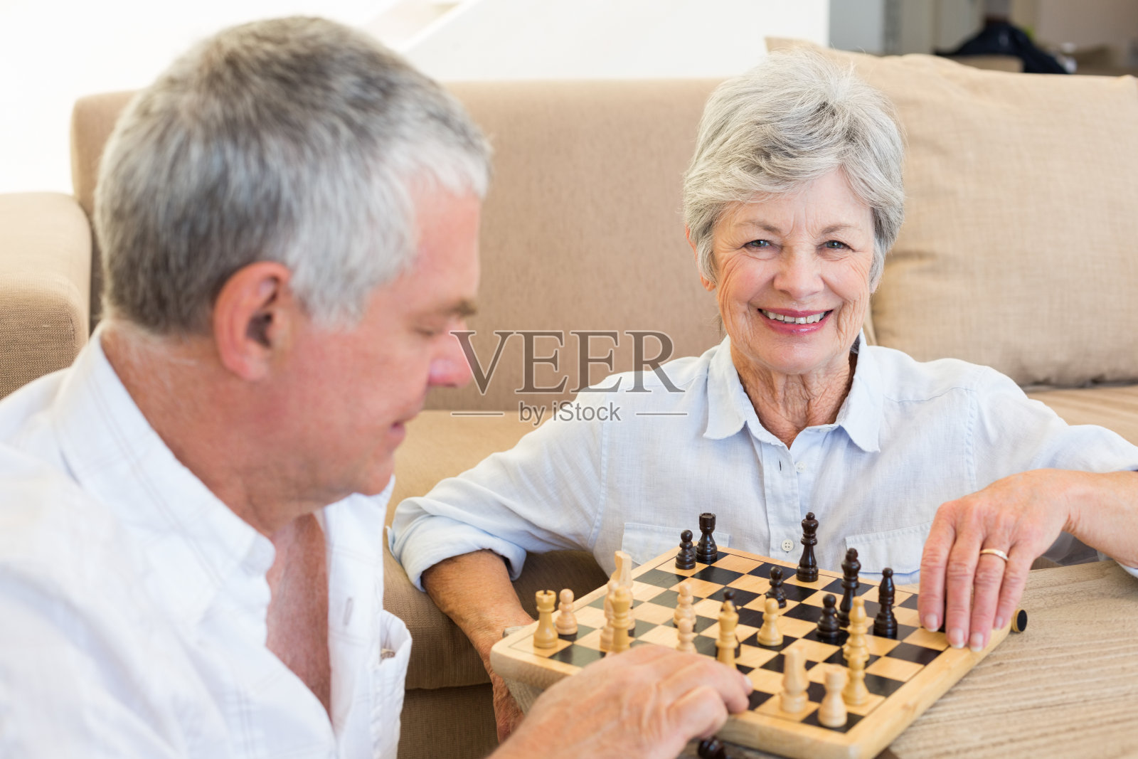 一对老年夫妇坐在地上下棋照片摄影图片
