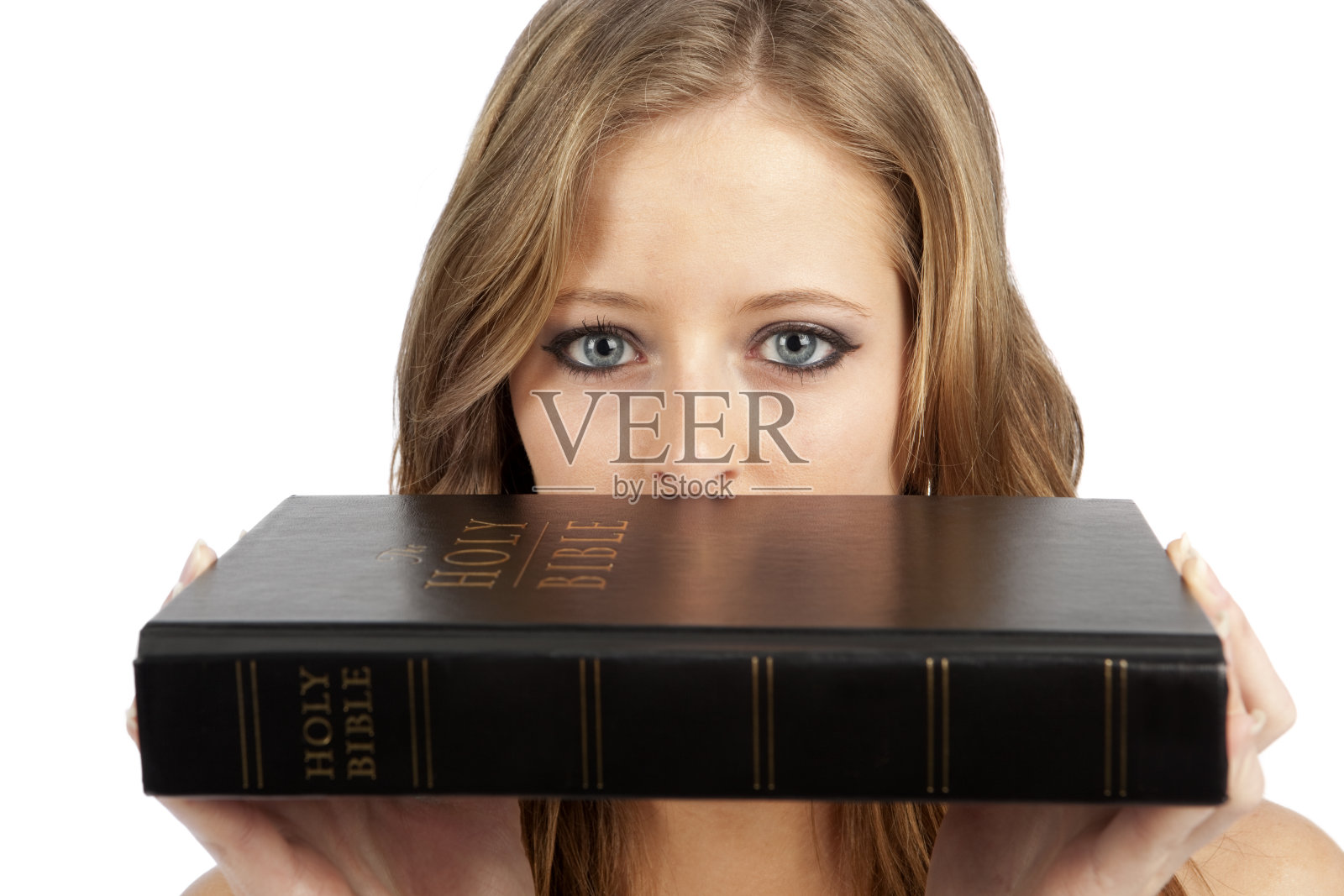 用神奇的眼睛看着《圣经》的女孩。照片摄影图片